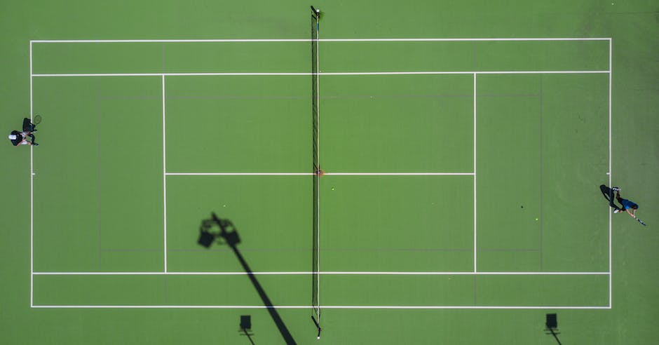 Image description: A tennis court with players engaged in a tennis match