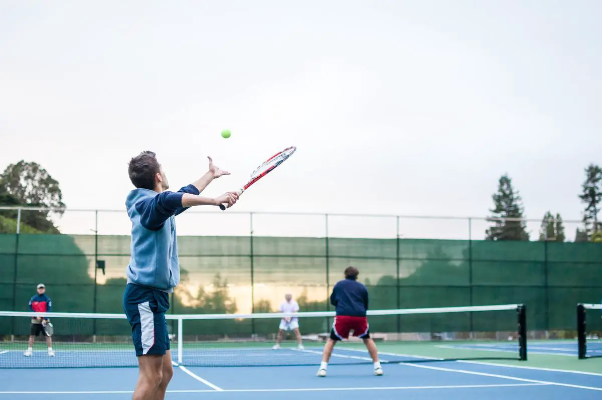 Two tennis players playing doubles on a tennis court