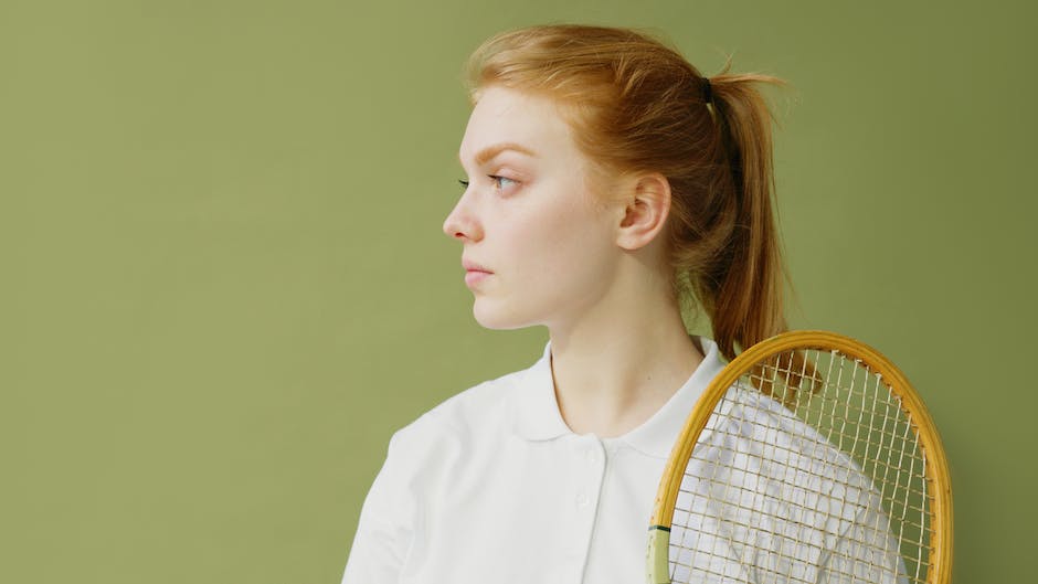 Image of a squash racquet with a person holding it, ready to play