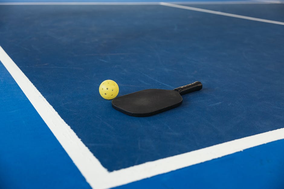 A person serving a pickleball with focus and precision.