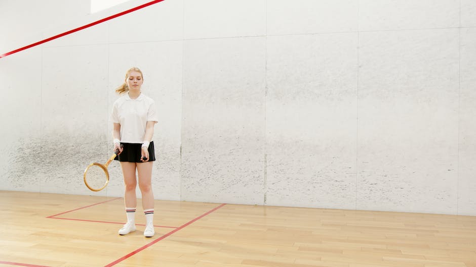 A person playing squash, focusing on hitting the ball with their racket.