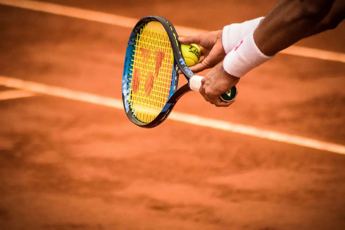 A person hitting a backhand shot in a tennis match.