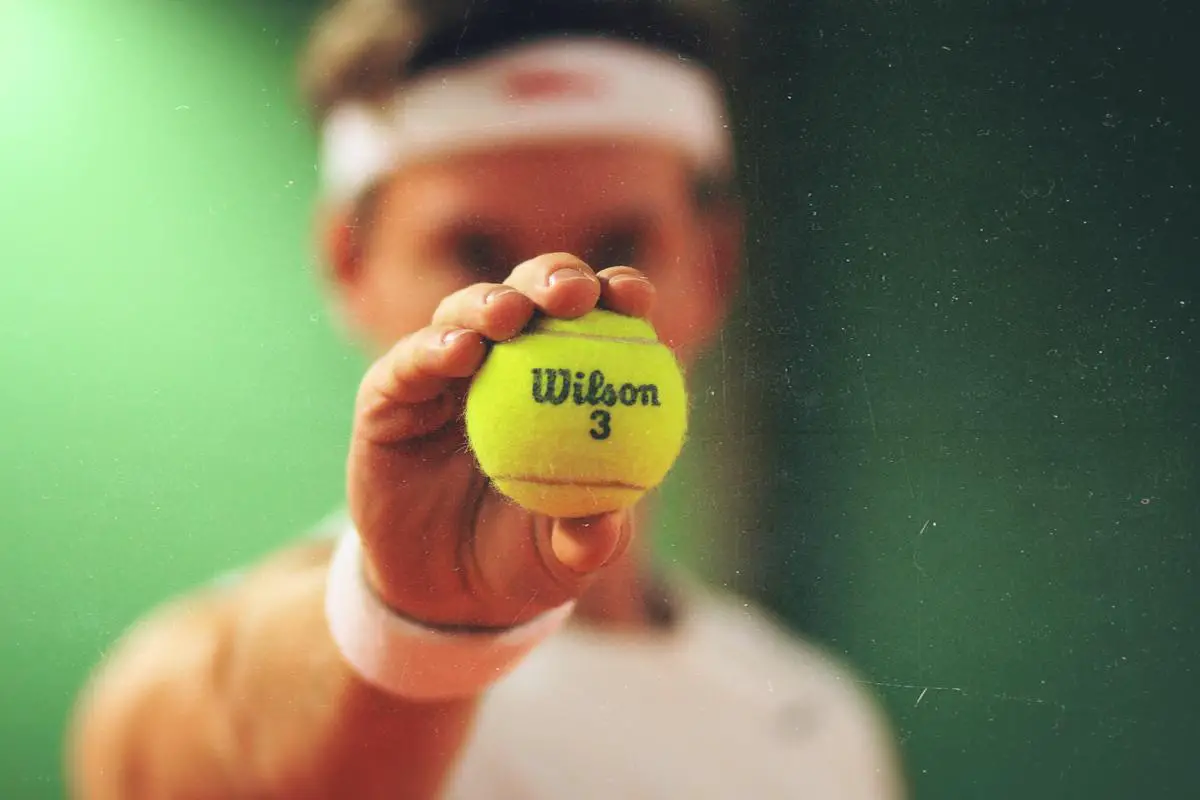 A person practicing tennis drills on a court, focusing on their technique and precision.