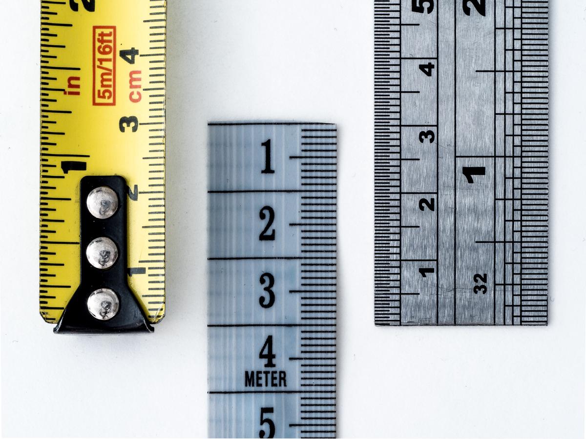 A person measuring a tennis racket grip size with a ruler