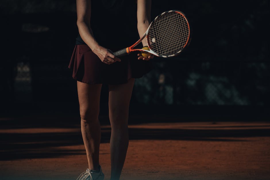 A person serving a tennis ball, showing the proper stance and technique.